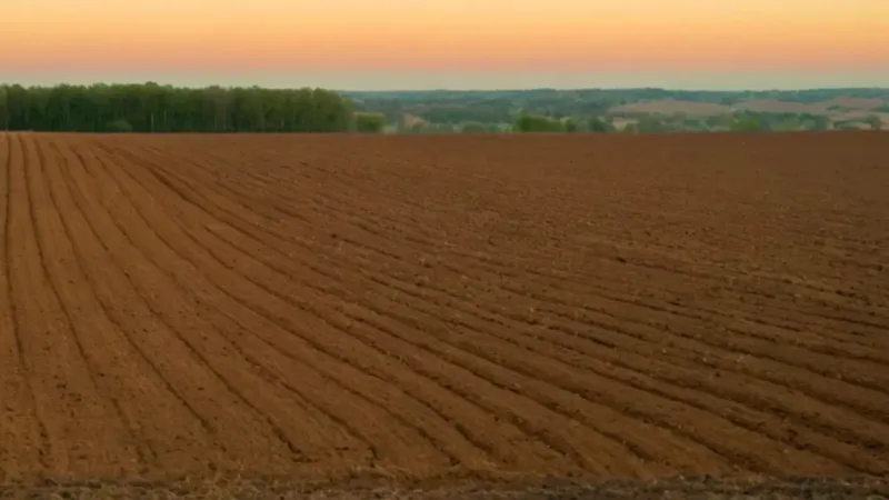 Un campesino descansa en el campo arado