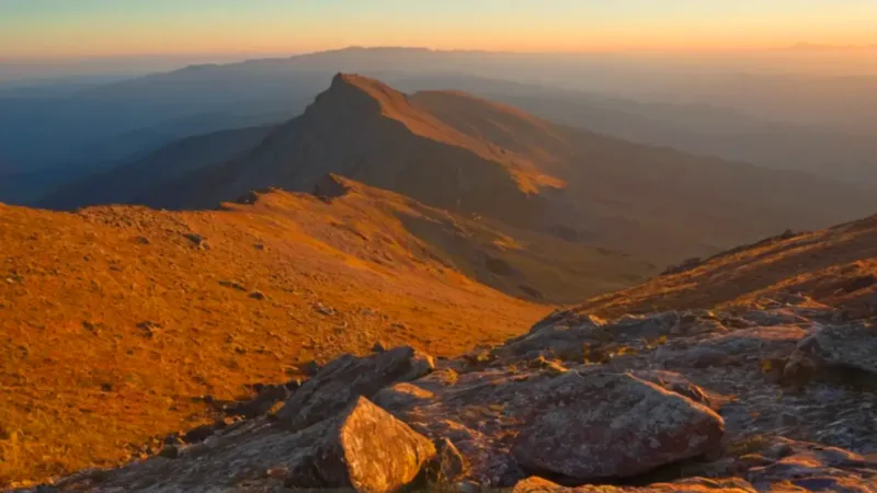 Una figura en la cumbre al atardecer