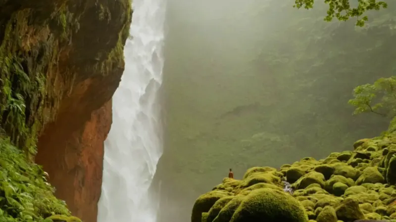 Persona frente a la inmensa cascada