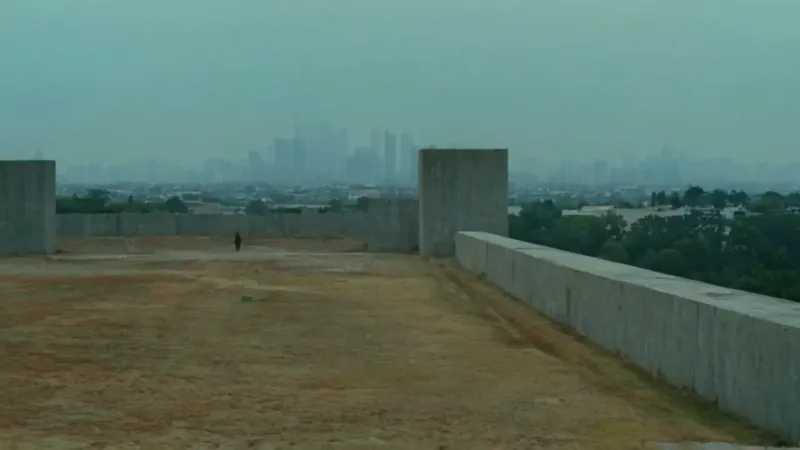 Una figura solitaria ante un muro opresivo