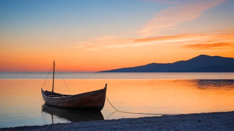 Una silueta contempla el barco al atardecer
