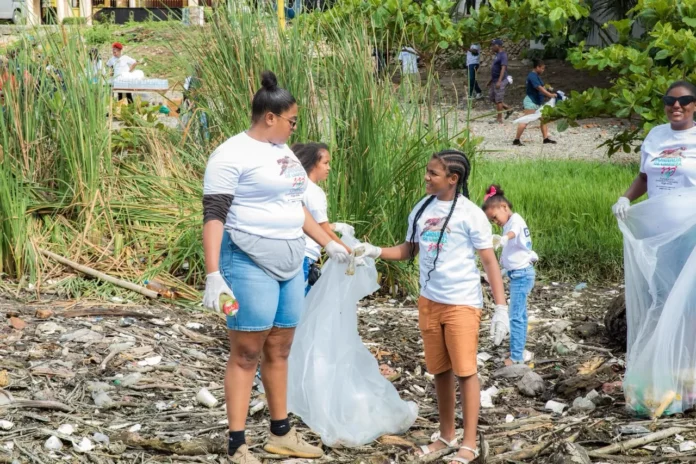 Jóvenes limpiando Playa Najayo por océanos.